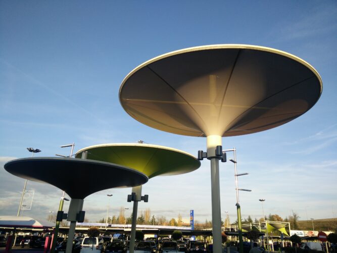 Cubierta textil tipo parasol con estructura central en espacio urbano