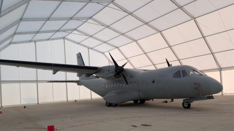 Carpa tipo hangar en el que aparece un avión cubierto por una carpa