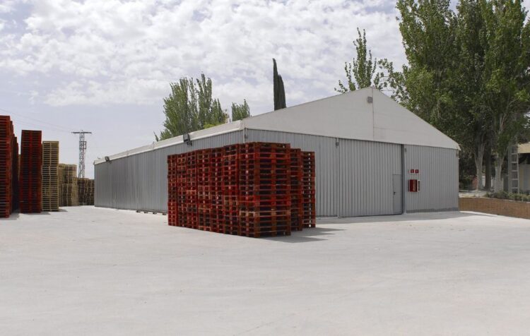 Industria provisional con carpas utilizada como almacén logístico con palets en exterior