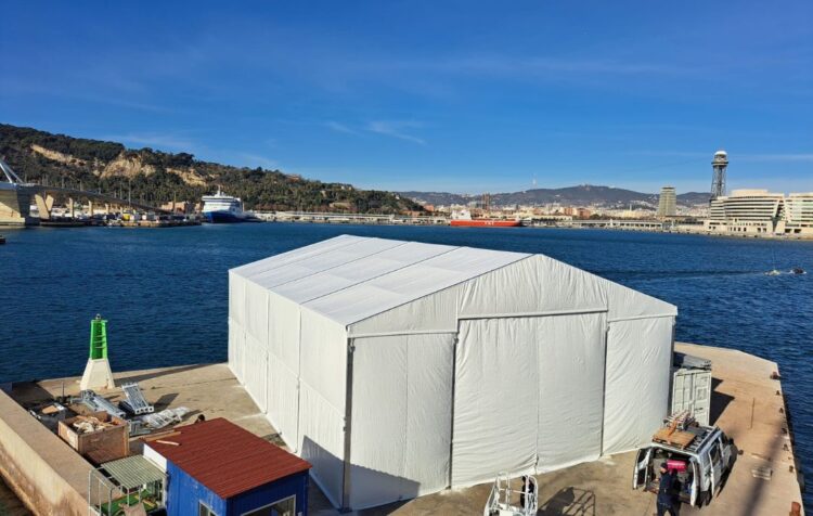 Industria provisional con carpas instalada en zona portuaria para almacenamiento y actividad logística