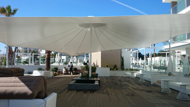 Vela tensada instalada en terraza de hotel para crear zona de sombra