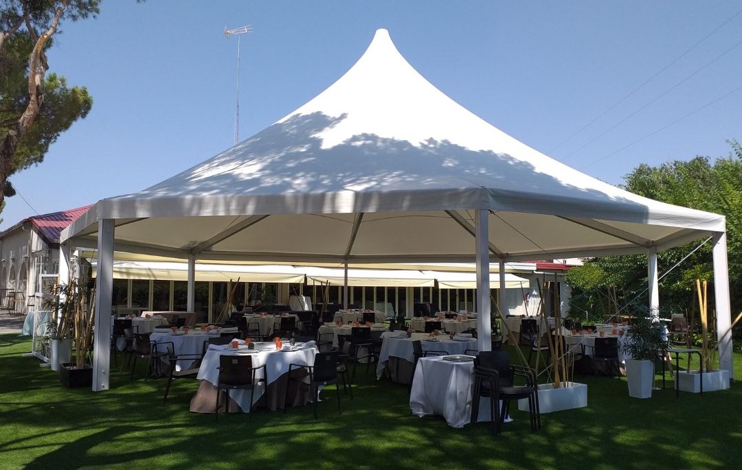 Alquiler de carpas para eventos tipo boda con montaje elegante en jardín y mesas preparadas